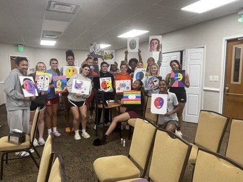 Young women sharing artwork during a creative workshop