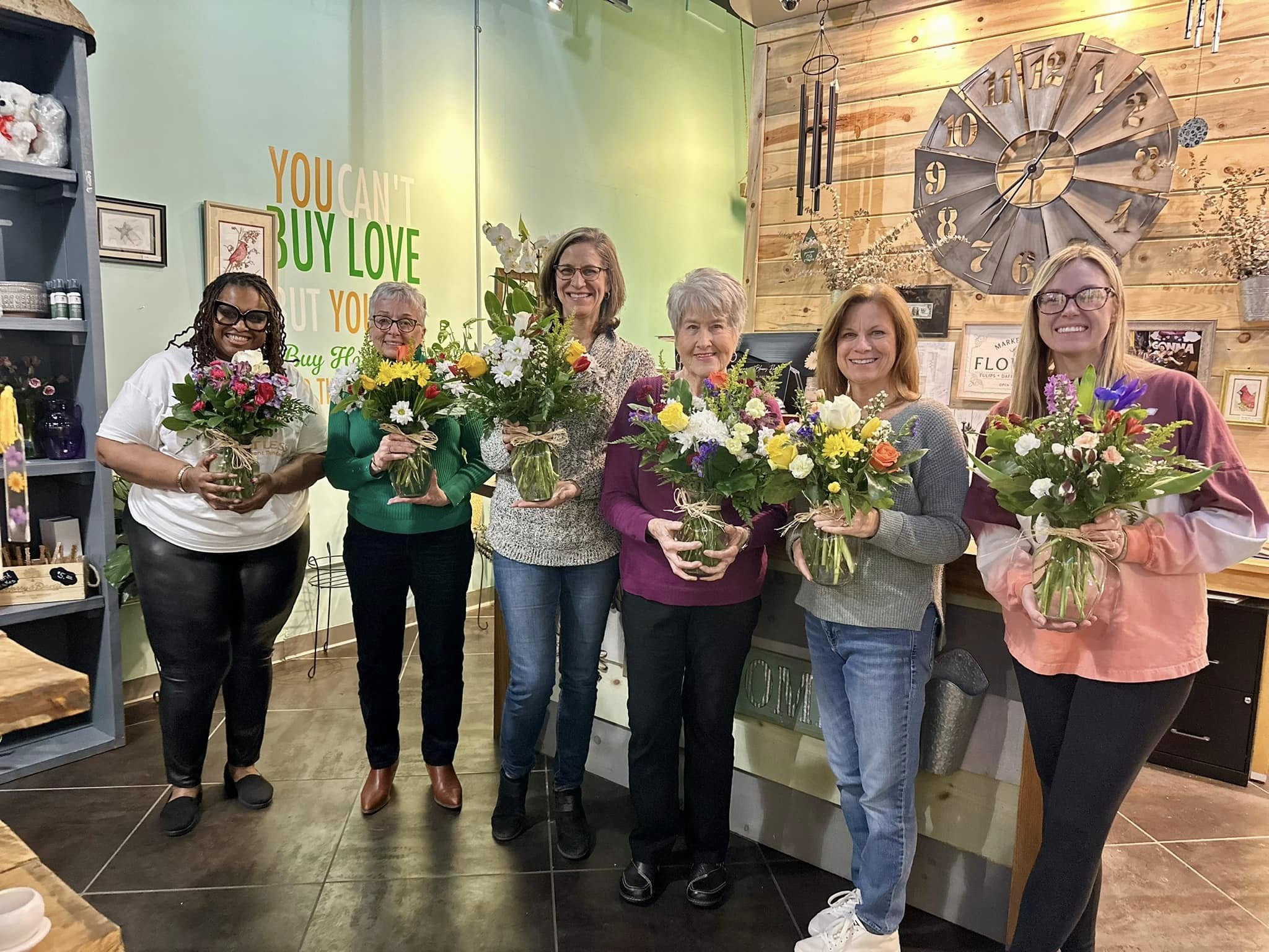 Women gathered with flowers during a Limitless EmpowHERment Foundation community moment
